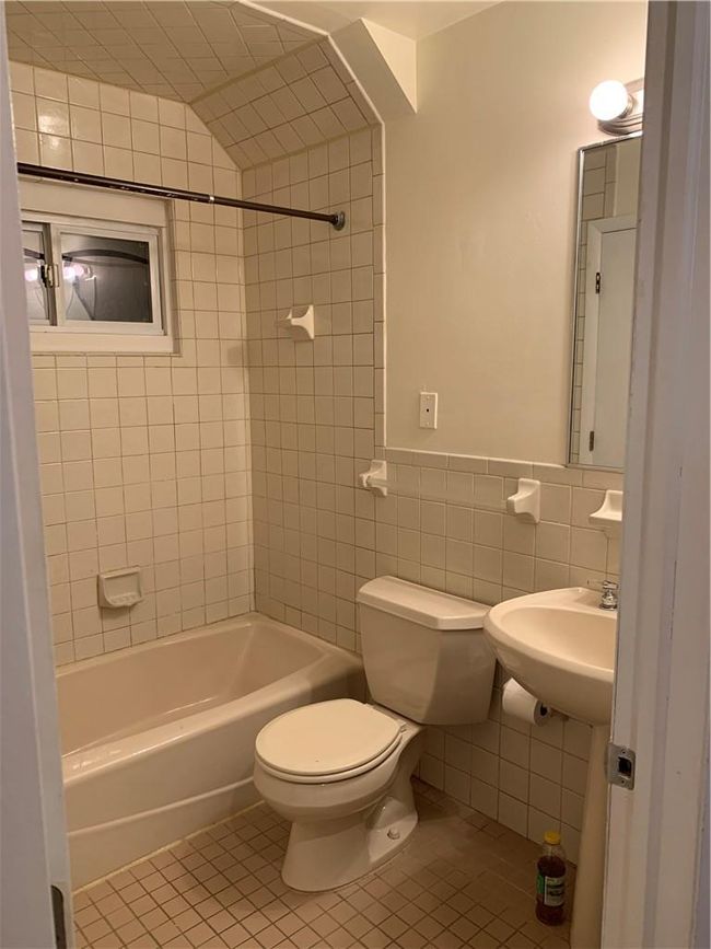 1st Fl Bathroom featuring tile walls, toilet, tiled shower / bath, and tile patterned floors | Image 18