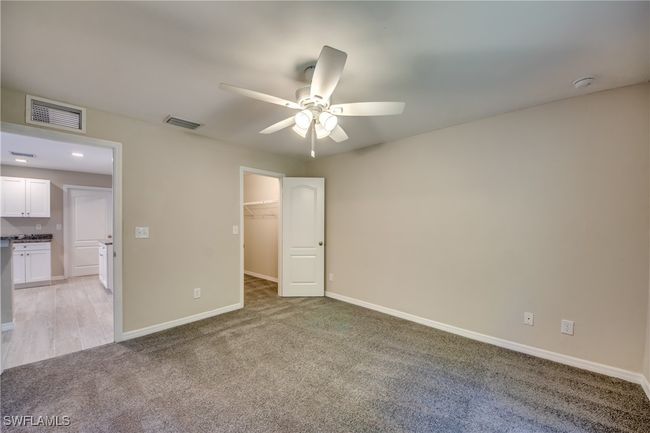 Unfurnished bedroom with baseboards, a spacious closet, visible vents, and light colored carpet | Image 31