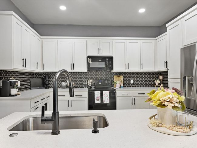 Kitchen featuring black appliances, a sink, white cabinets, tasteful backsplash, and recessed lighting | Image 21