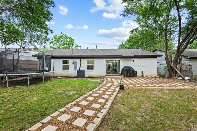 Rear view of house with a trampoline, cooling unit, a patio, and brick siding | Image 35