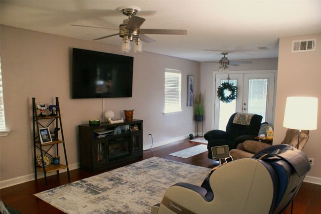 Living room featuring a ceiling fan and dark wood-style flooring | Image 11