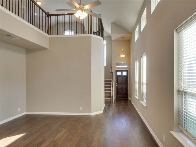 Open floor plan with iron balusters and game room overlooking the living room. | Image 9