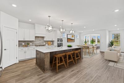 (Photo of decorated model, finishes will vary) This chef’s kitchen is equipped with a versatile center island, quartz countertops and plenty of room for storage. | Image 1