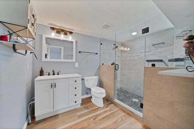 Full bathroom with wood finished floors, vanity, and a stall shower | Image 14