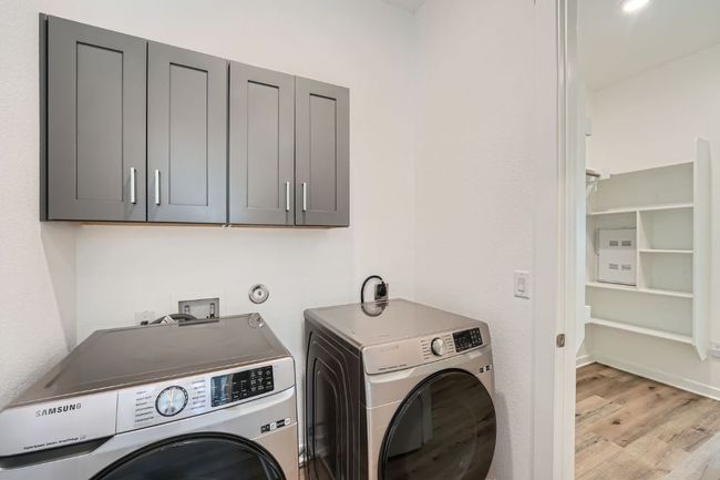 Laundry room with cabinet space, light wood-style flooring, and independent washer and dryer | Image 23