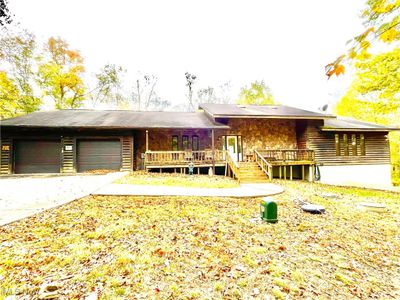 View of front of home with a garage and a wooden deck | Image 1