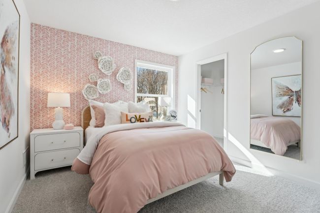 Photo is of the actual model. One of three generously sized upper level secondary bedrooms with spacious closets. | Image 25