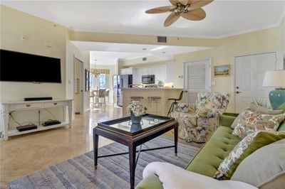 Living room featuring ceiling fan with notable chandelier and crown molding | Image 1