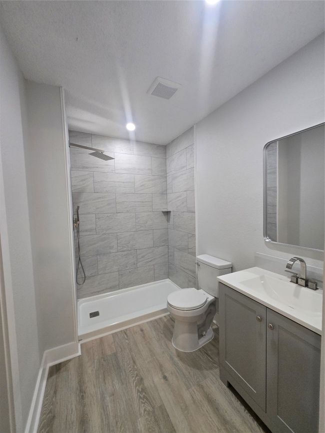 Full bathroom featuring vanity, wood finished floors, and a tile shower | Image 16