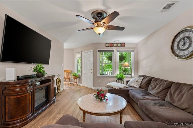 Living area featuring light wood-type flooring, a ceiling fan, and baseboards | Image 10