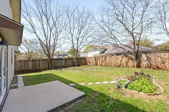 View of yard featuring a vegetable garden, a fenced backyard, and a patio area | Image 29