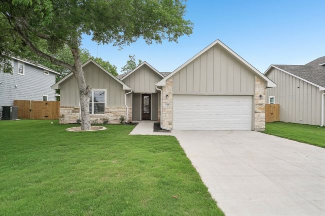 View of front of home with a front lawn, central air condition unit, concrete driveway, board and batten siding, and a garage | Image 34