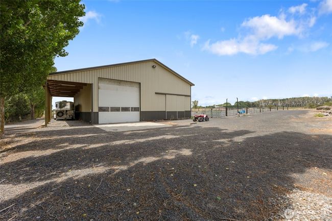 Backside of the barn with horse trailer drive through storage. This barn has outdoor lights that allow for evening riding in the arena. | Image 33