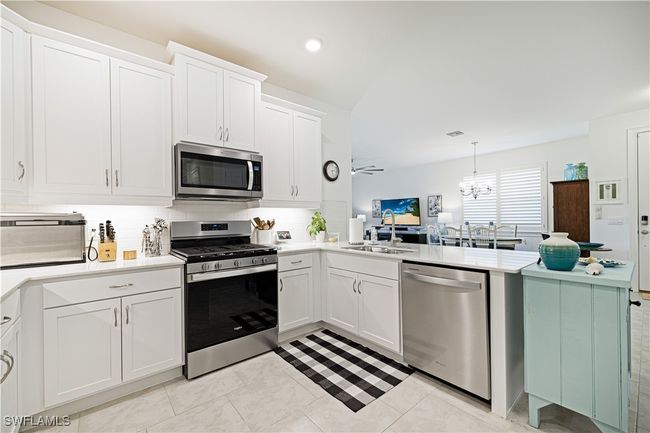 Kitchen featuring appliances with stainless steel finishes, tasteful backsplash, a peninsula, light countertops, and recessed lighting | Image 12