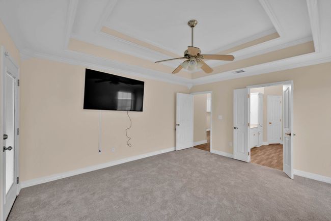 Unfurnished bedroom with a raised ceiling, carpet, crown molding, and connected bathroom | Image 18