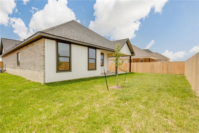 Rear view of house featuring a shingled roof, brick siding, and board and batten siding | Image 36