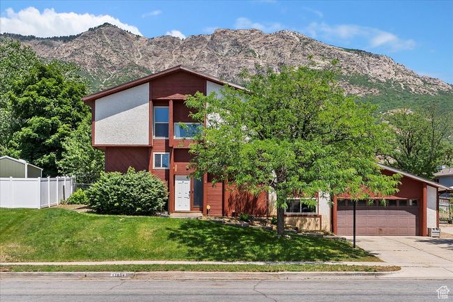 Exterior of home with concrete driveway, a garage, RV pad, a mountain view, cedar and stucco siding | Image 31