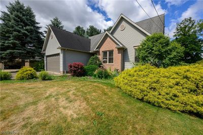 View of front facade with a garage and a front lawn | Image 2