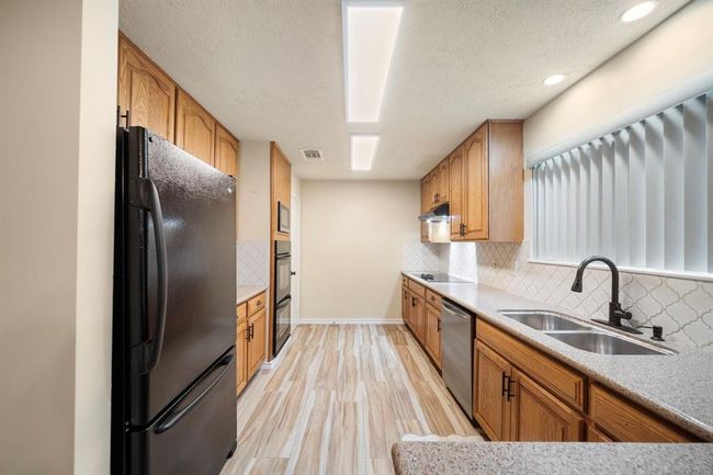 Showcasing double ovens, a sleek cooktop, and ample cabinetry, this kitchen is designed for everyday efficiency. | Image 11