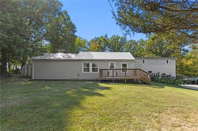 Front view of property with a yard, a wooden deck, and a shed | Image 1