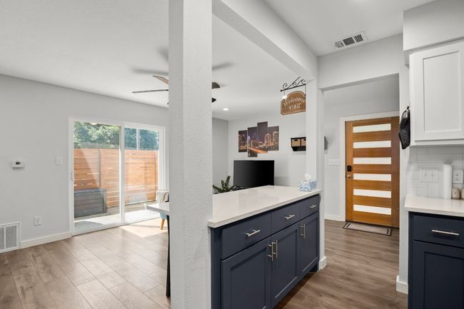 Kitchen with a ceiling fan, light countertops, white cabinetry, and a breakfast bar area | Image 14