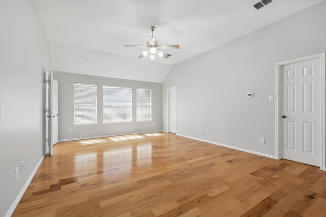 Primary Bedroom with ceiling fan, lofted ceiling, light wood-style flooring, and baseboards | Image 14