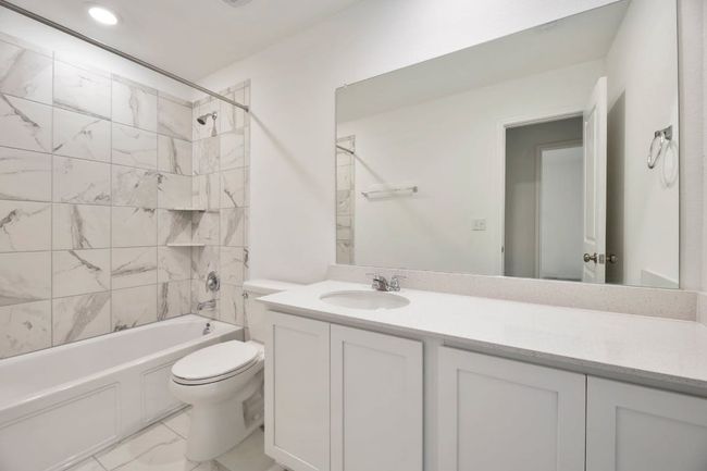 Bathroom featuring marble finish floors, vanity, and washtub / shower combination | Image 30