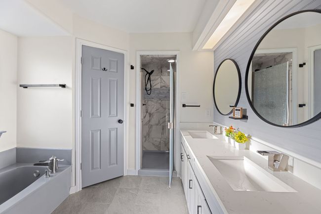 Bathroom featuring a bath, double vanity, a sink, and a stall shower | Image 31