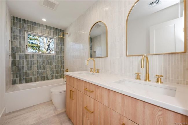 Bathroom with shower combination, tile walls, and double vanity | Image 23