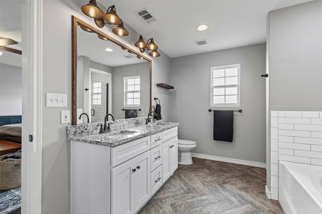 Ensuite bathroom featuring plenty of natural light, a bath, double vanity, baseboards, and recessed lighting | Image 22