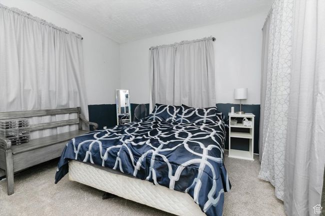 Carpeted bedroom featuring a textured ceiling | Image 19