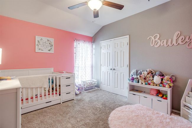 Bedroom with carpet, vaulted ceiling, a closet, a ceiling fan, and a crib | Image 32