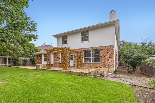 Back of property featuring a pergola, a patio, a chimney, brick siding, and stucco siding | Image 40