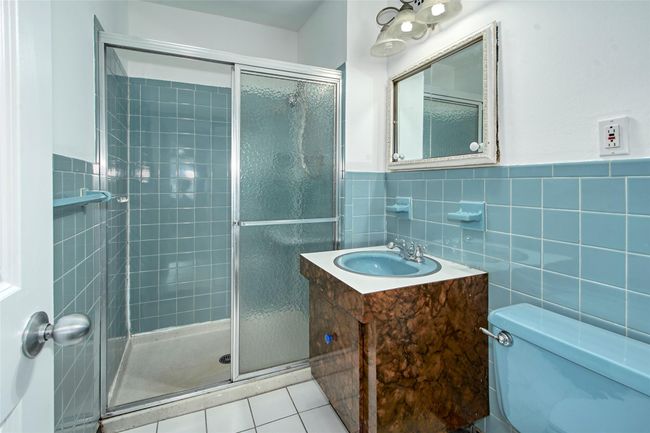 Full Primary bathroom with vanity, tile walls, a shower stall, tile patterned floors, and wainscoting | Image 13