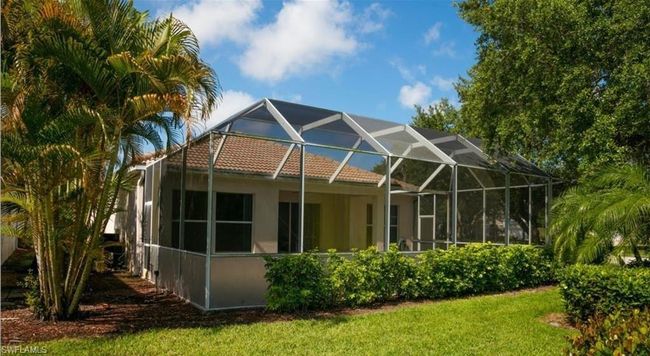 Back of property with a lanai and a lawn | Image 15