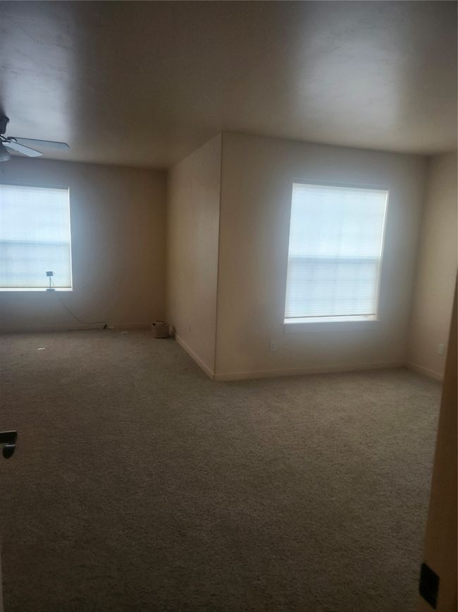 Carpeted empty room featuring a ceiling fan and baseboards | Image 8