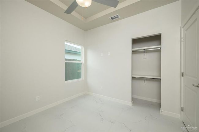 Unfurnished bedroom featuring baseboards, marble finish flooring, a closet, and a ceiling fan | Image 13