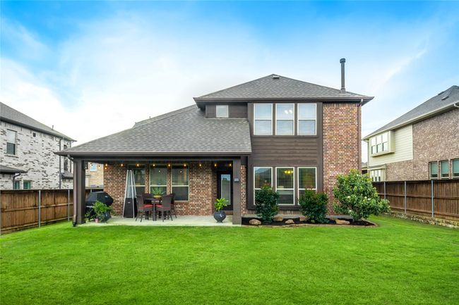 Rear view of house with brick siding, a patio, and a shingled roof | Image 37