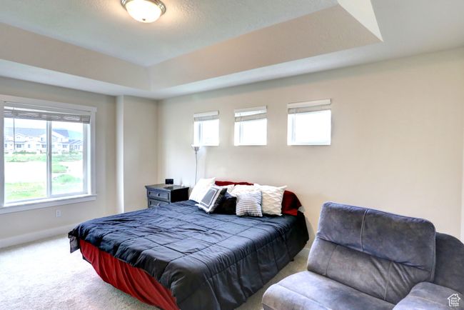 Bedroom with a raised ceiling, carpet floors, and baseboards | Image 11
