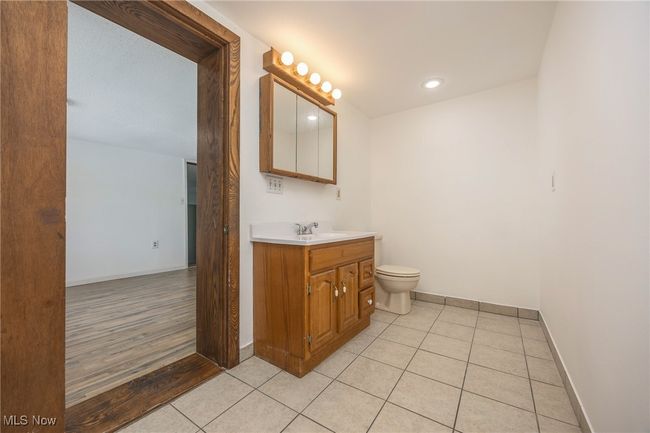 Bathroom featuring vanity, baseboards, toilet, tile patterned floors, and recessed lighting | Image 10