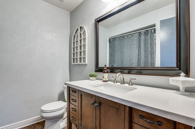 Bathroom with a textured wall, vanity, and wood finished floors | Image 21