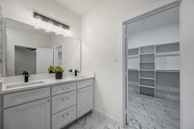 Bathroom with baseboards, marble finish floor, double vanity, and a sink | Image 21