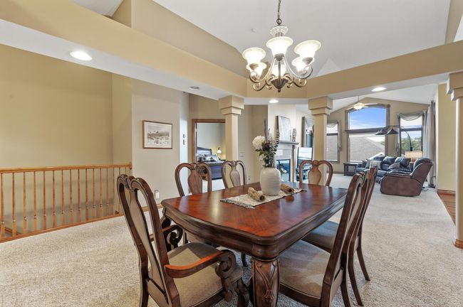 Soaring vaulted ceilings and an open concept floor plan offer an incredibly spacious feel to the main level. Generous dining space provides a perfect area to host lively family gatherings with plenty of room for extended family and friends! | Image 13
