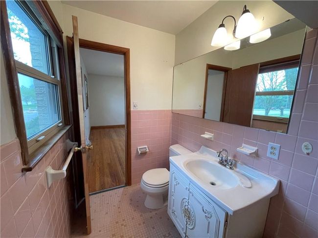 Bathroom with toilet, tile walls, wainscoting, and plenty of natural light | Image 19