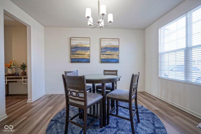 dining room with baseboards, a wealth of natural light, wood finished floors, and a chandelier | Image 23