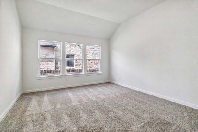 Carpeted spare room with vaulted ceiling and baseboards | Image 20