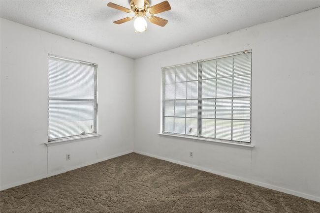 Empty room featuring plenty of natural light, ceiling fan, carpet floors, and a textured ceiling | Image 21
