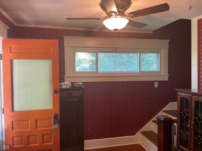 foyer featuring a ceiling fan, healthy amount of natural light, wallpapered walls, and ornamental molding | Image 12
