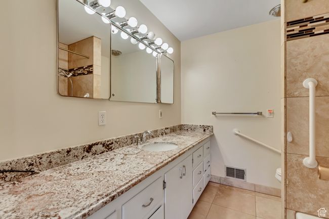 Bathroom with vanity, a shower, toilet, tile patterned flooring, and visible vents | Image 17