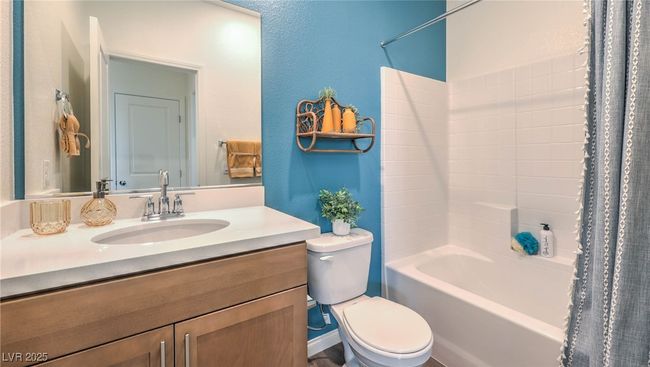 Photo is representational only; actual home finishes may vary. Full bath with shower / bath combo with shower curtain, vanity, and toilet | Image 6